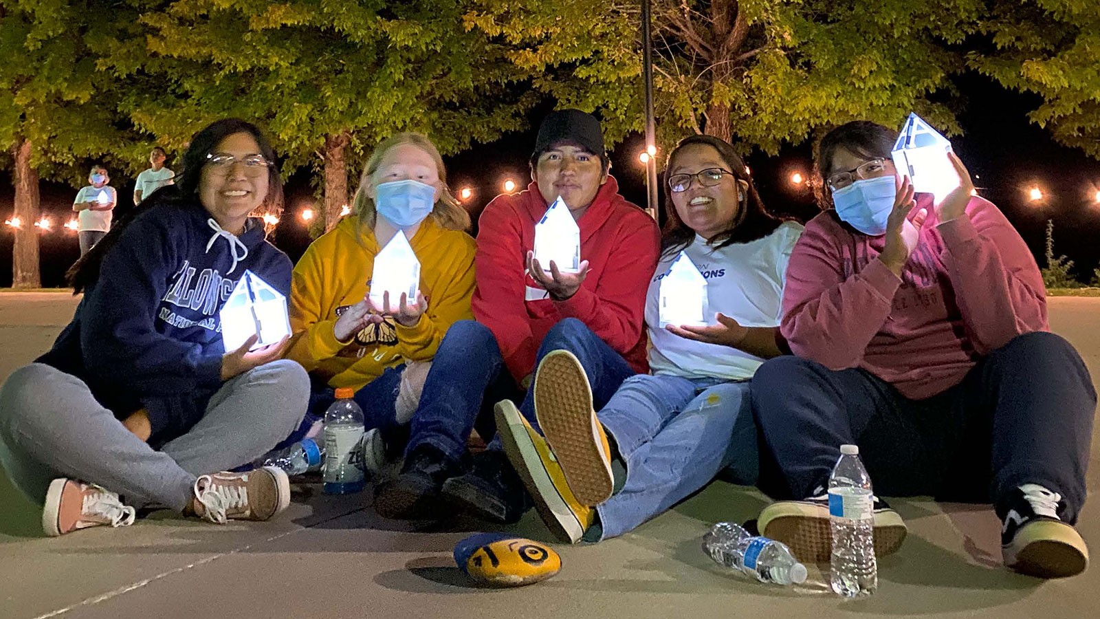 Utah State University students hold lanterns shaped like the top of Old Main's tower.
